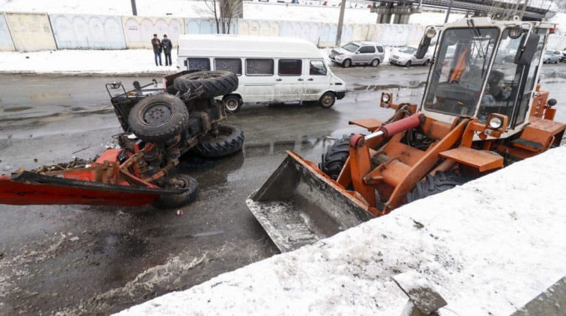 На Столичном шоссе снегоуборочный трактор упал с моста от удара грузовика