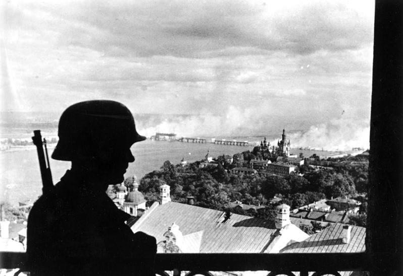 Немецкий солдат на фоне горящего моста через Днепр