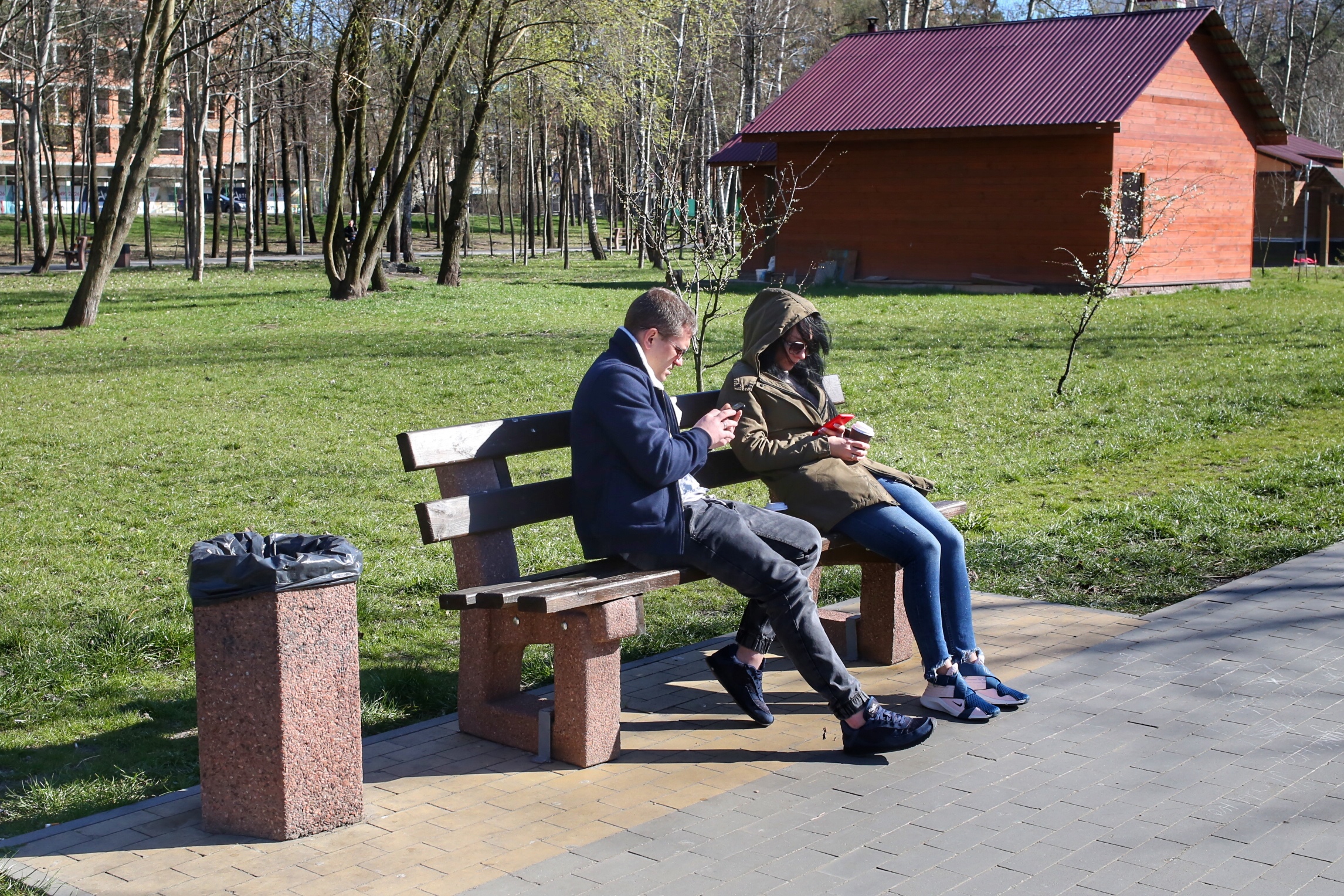 девушка и парень на скамейке с телефонами, парк, карантин