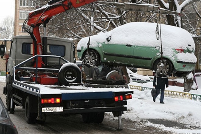 В снігу не заховаєшся. В умовах снігопаду евакуатори забирають автівки – фото