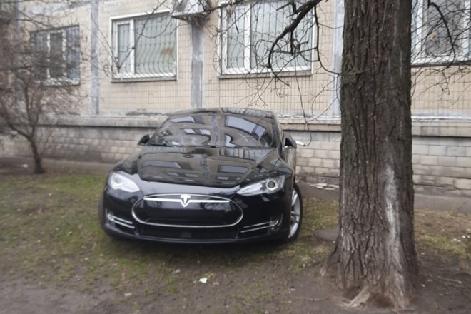 Фото дня. Tesla на газоні під “панелькою” заряджається від подовжувача з квартири