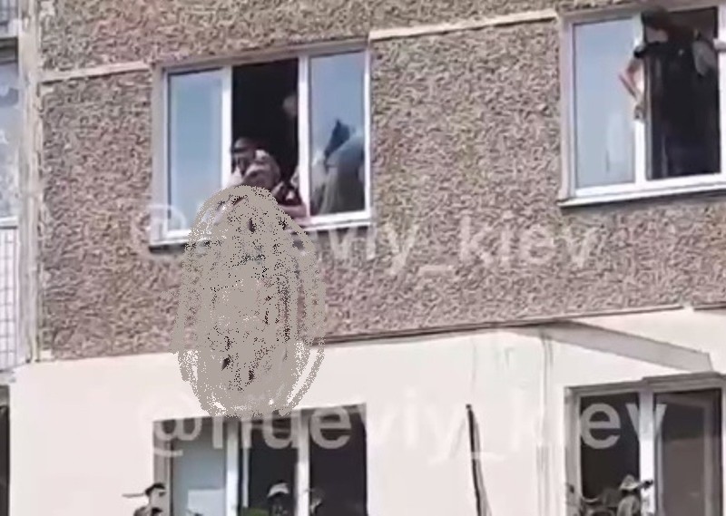 На Бориспільській жінка висить з вікна догори ногами – що відбувається (ВІДЕО)