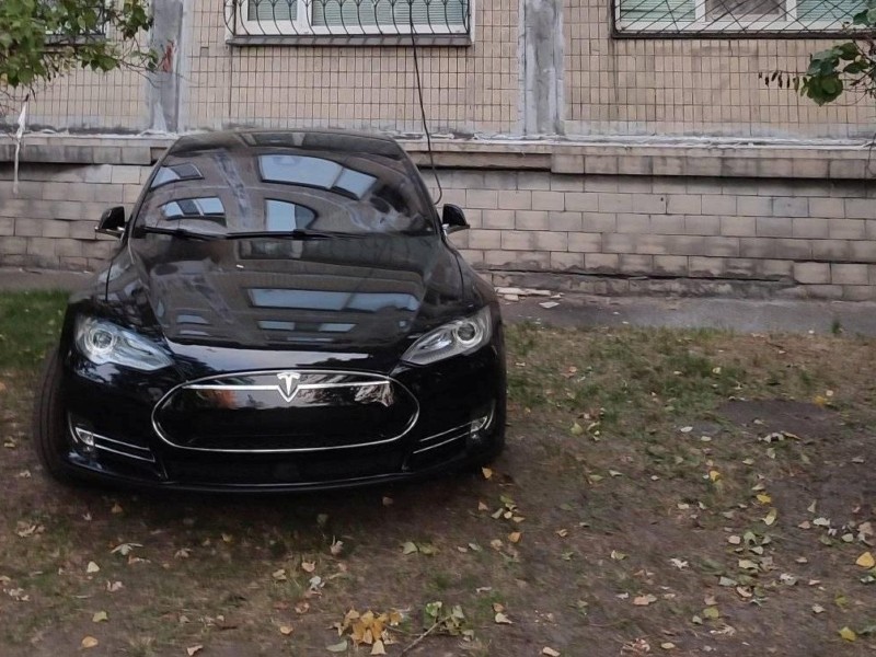“В хрущовці, зате на Tesla”: автівку щодня заряджають на газоні під будинком, кияни обурюються