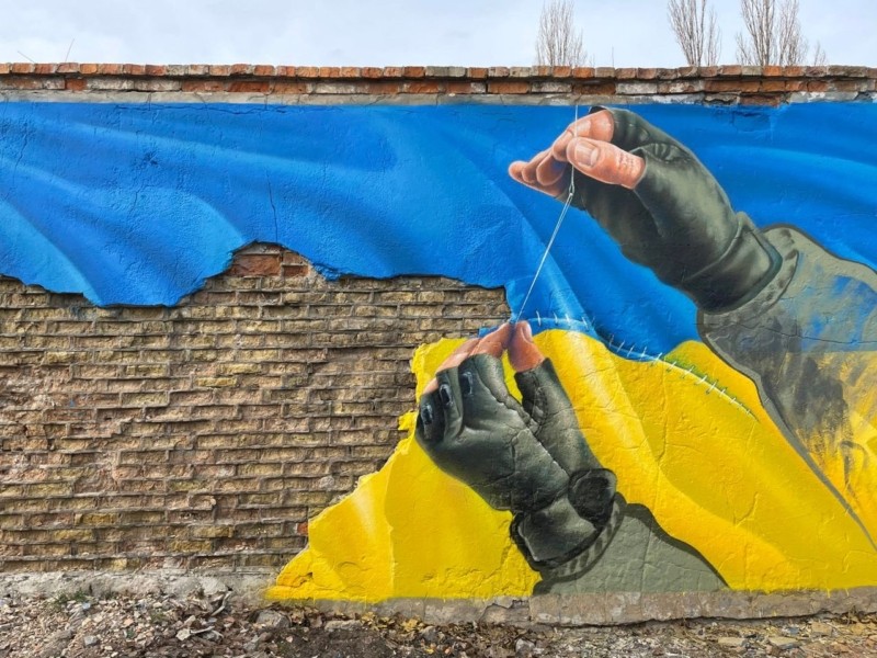 Руки, що зшивають прапор України. На Оболоні з’явився символічний мурал